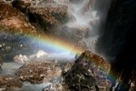 Regenbogen im Wasserfall im aufgehenden Licht der Sonne.